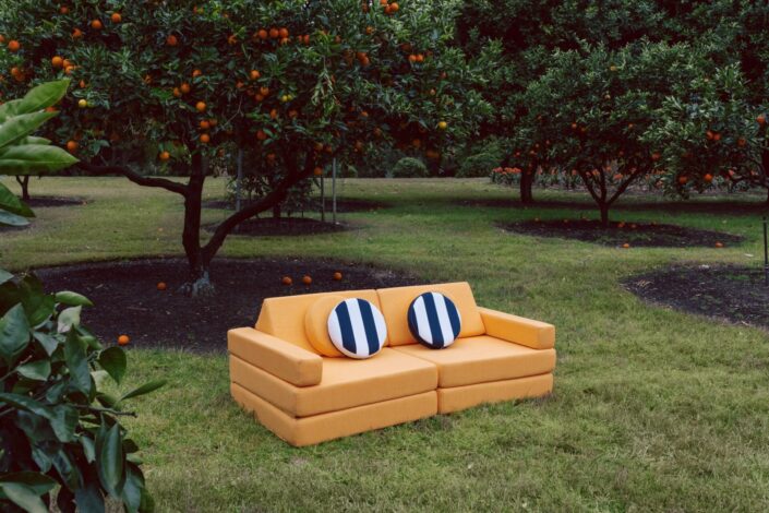 Orange couch on grass. Running Under the Sprinkler product photography