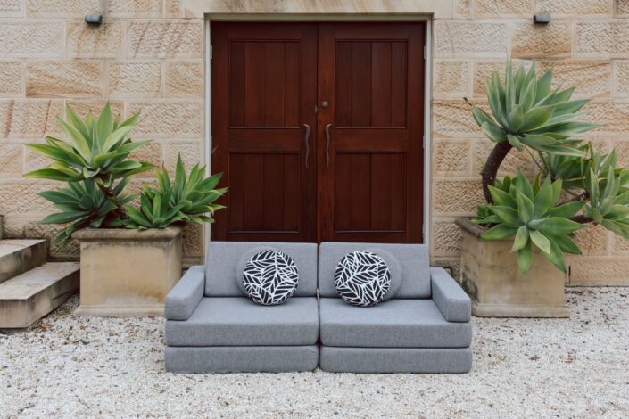 Grey couch in front of building. Running Under the Sprinkler product photography