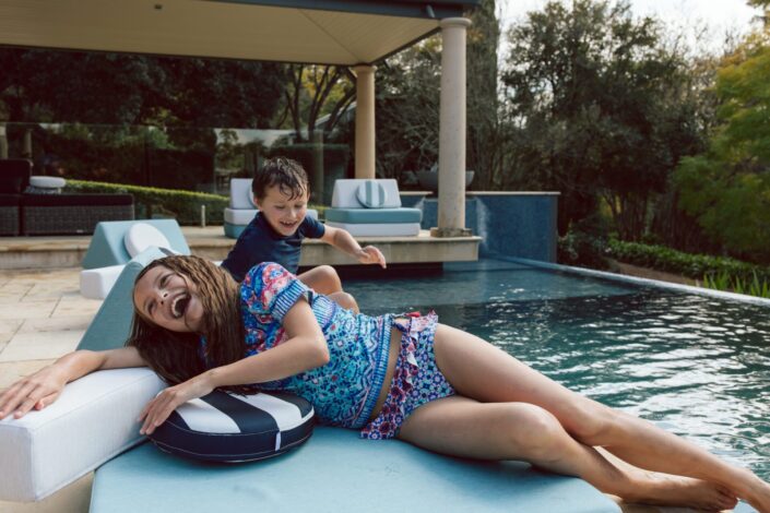 Kids play on couch by pool. Running Under the Sprinkler product photography